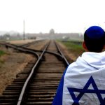 איש עם דגל על פסי רכבת